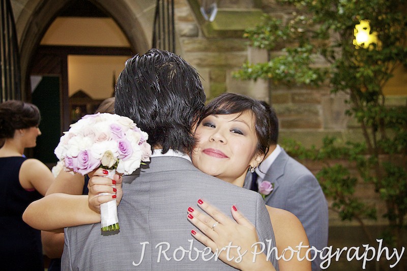 Groom being hugged by his sister - wedding photography sydney